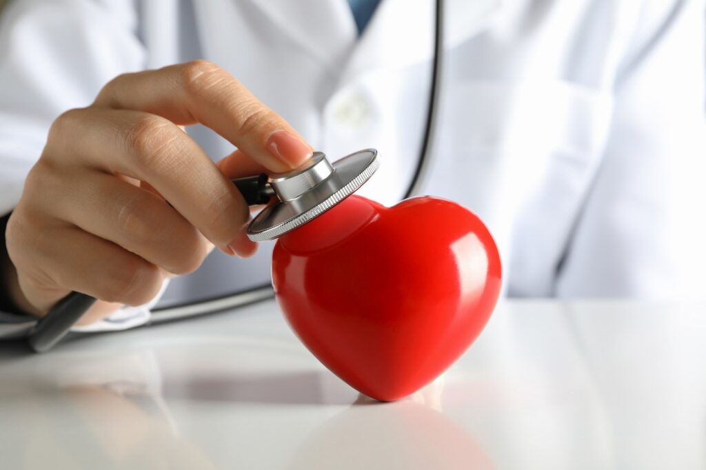Female doctor with stethoscope checking heart beat