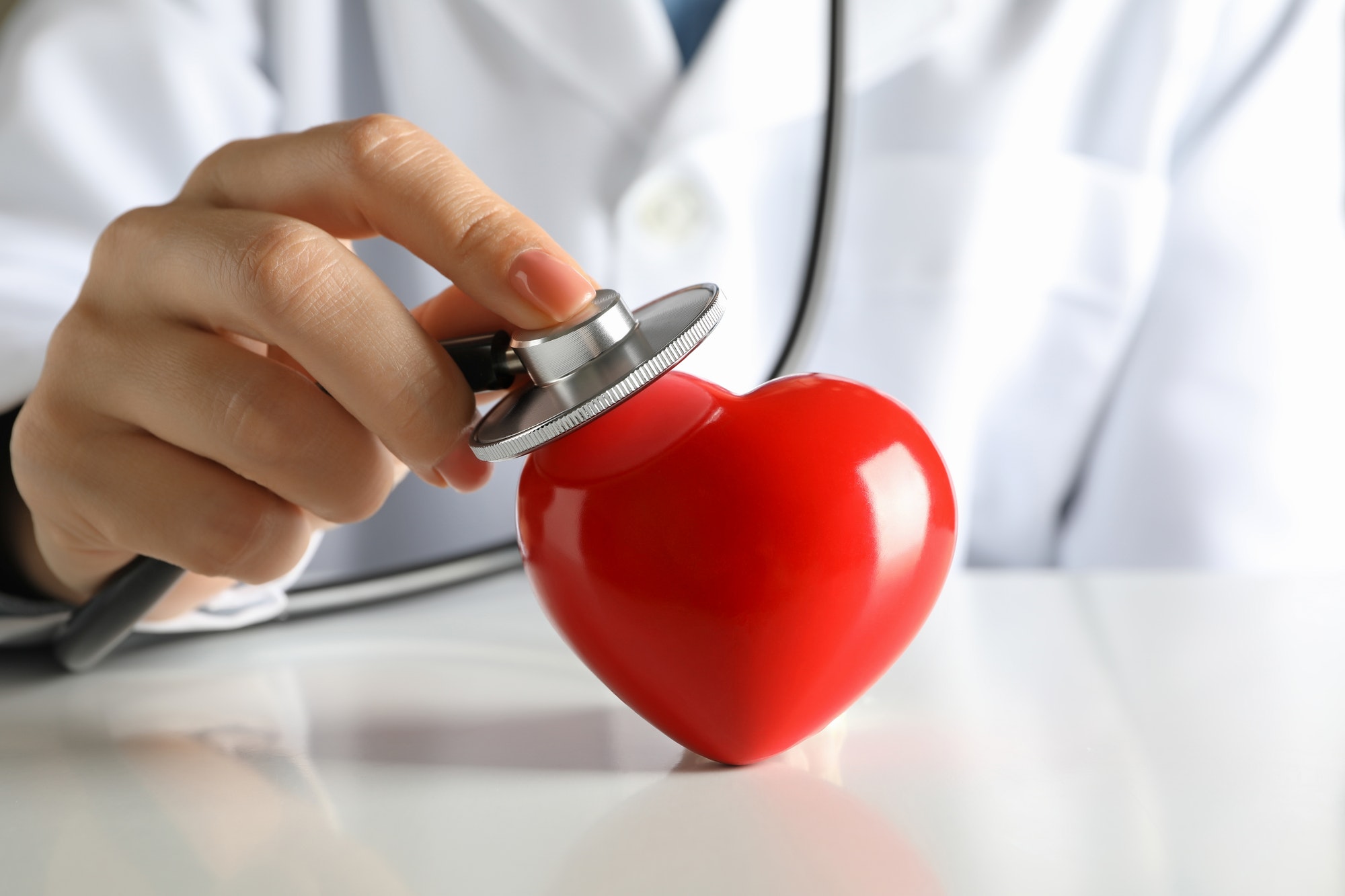 Female doctor with stethoscope checking heart beat