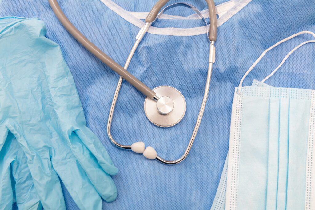 Health and cardio surgery equipment. Medical Stethoscope, disposable mask glove and coat, top view